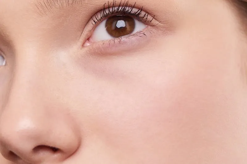 Application d'un rouge à lèvres longue tenue sur les lèvres d'une mariée, avec crayon contour comme base et technique du buvardage