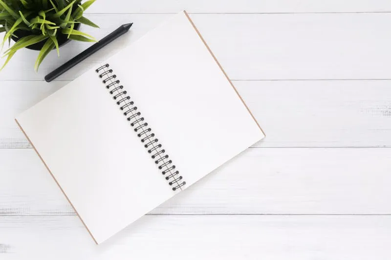 Carnet ouvert à côté d'un jeu d'oracle, stylo posé dessus