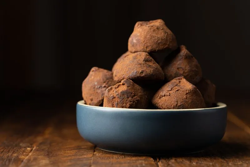 Boules d'énergie enrobées de cacao, empilées dans un bol
