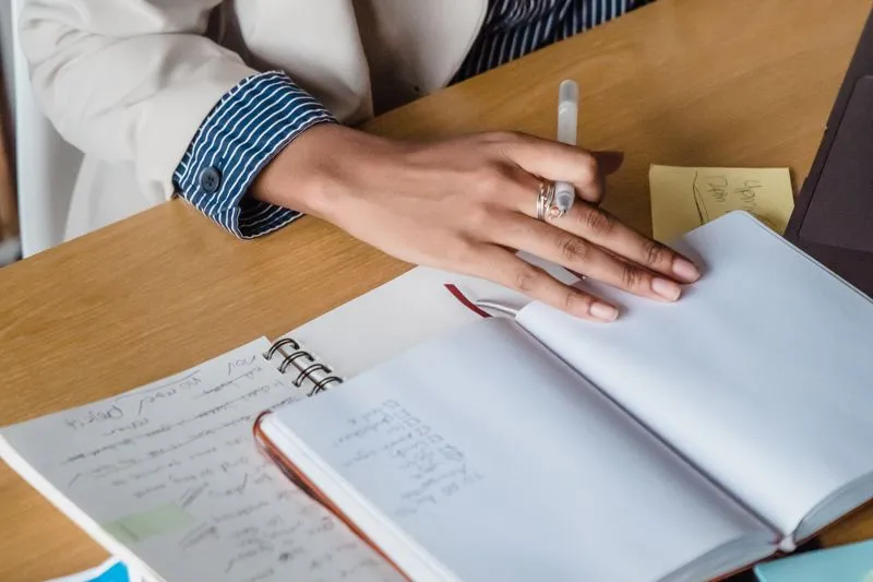 Femme qui écrit dans un carnet à son bureau