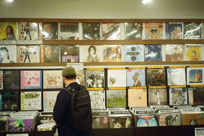 Client parcourant les bacs de vinyles dans un disquaire indépendant
