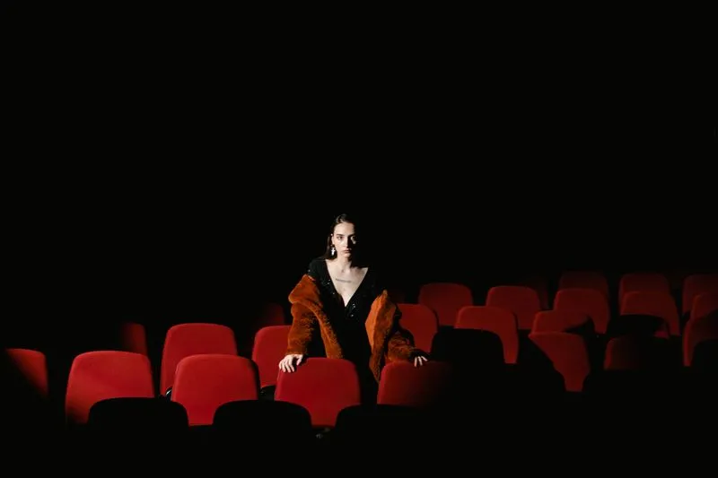 Spectatrice seule dans une salle de cinéma plongée dans l'obscurité