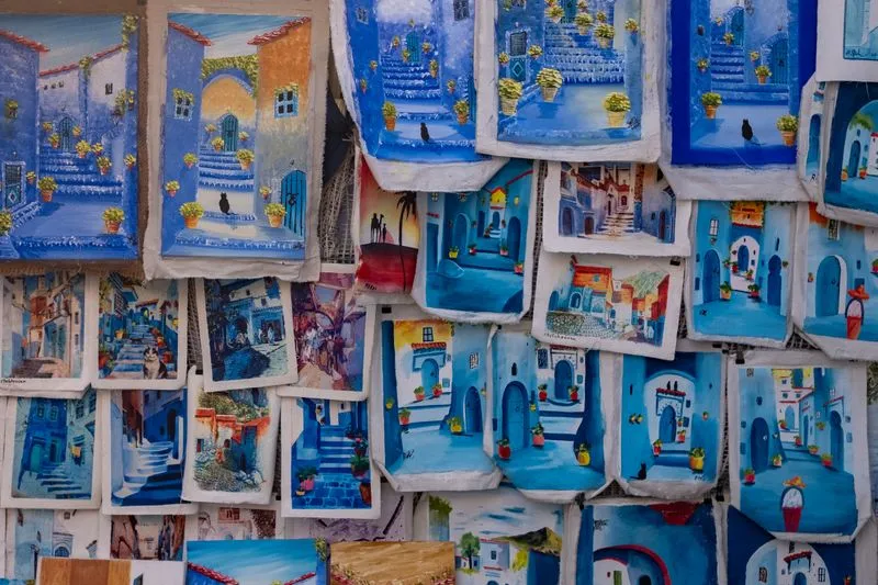 Étals de peintures artisanales bleues à l'effigie des ruelles de Chefchaouen, au Maroc