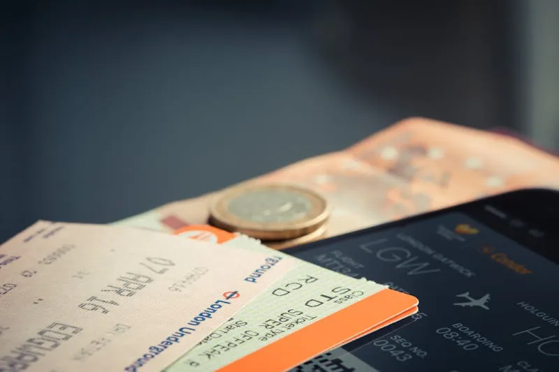 Billets de train, pièce et téléphone affichant une carte d'embarquement