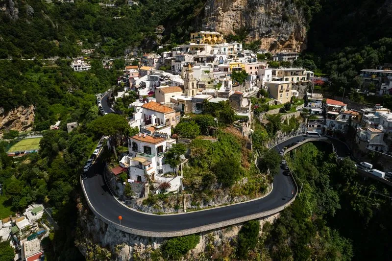 Vue aérienne de la route de la côte amalfitaine, en épingle autour d'un village accroché à la falaise