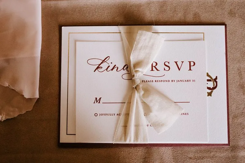 Carton réponse noué d'un ruban, imprimé « RSVP » avec une date limite de réponse au 31 janvier