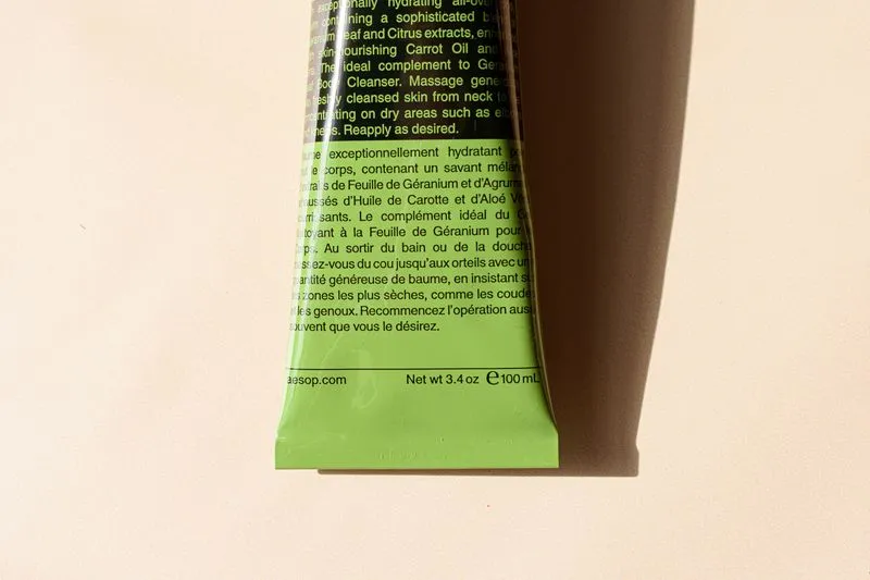 Dos d'un tube de soin vert couvert de petits caractères en anglais et en français, avec la contenance de 100 ml en bas