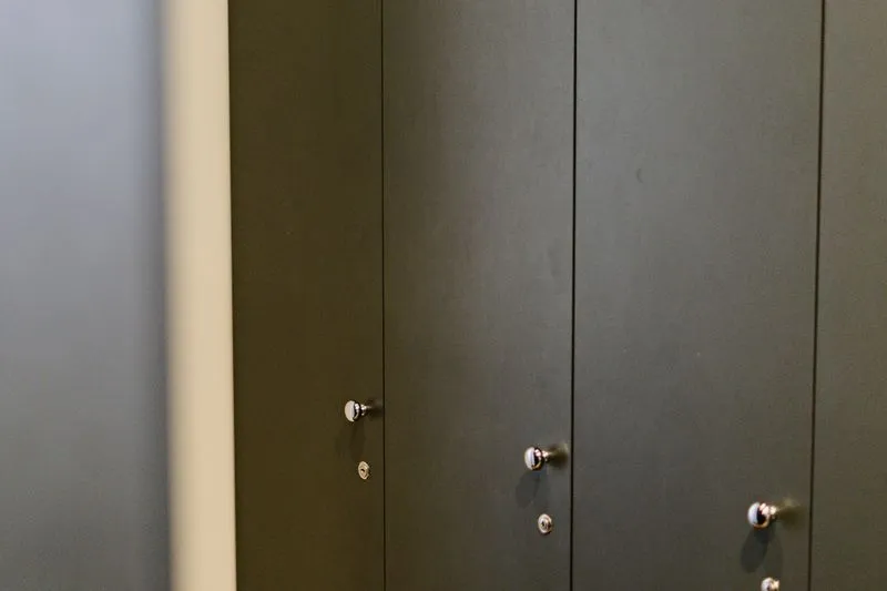 Portes de casiers gris foncé fermées, chacune avec sa petite serrure à clé