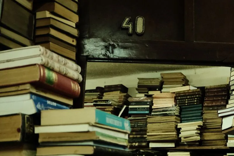 Piles de livres anciens aux couvertures usées sur des étagères