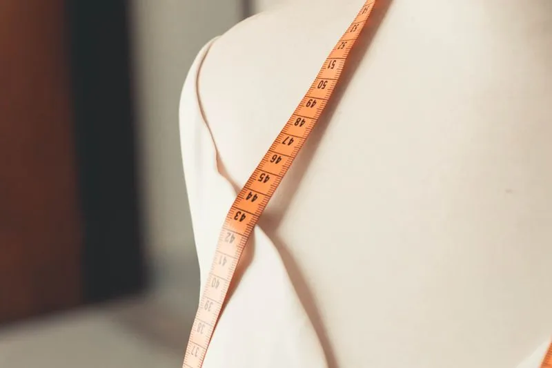 Mètre ruban posé sur l'épaule d'un mannequin de couturière