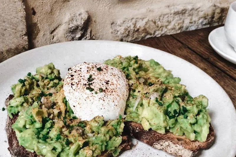 Tartine de pain complet garnie d'avocat écrasé et d'un œuf poché