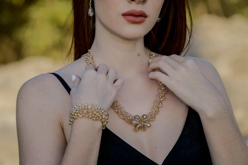 Collier de perles et boucles d'oreilles posés sur une robe de soirée