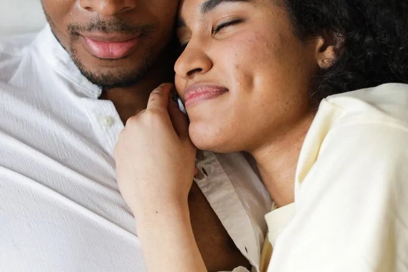 Couple blotti l'un contre l'autre, elle a les yeux fermés contre sa joue