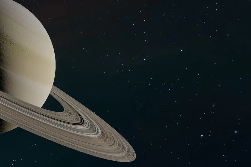 La planète Saturne et ses anneaux en gros plan, sur un fond spatial étoilé