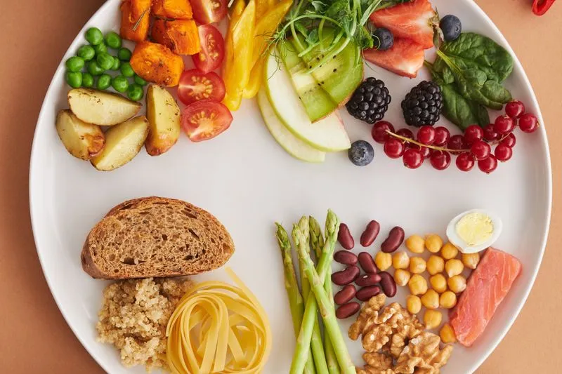 Assiette composée de légumineuses, de noix, de saumon et de fruits et légumes variés