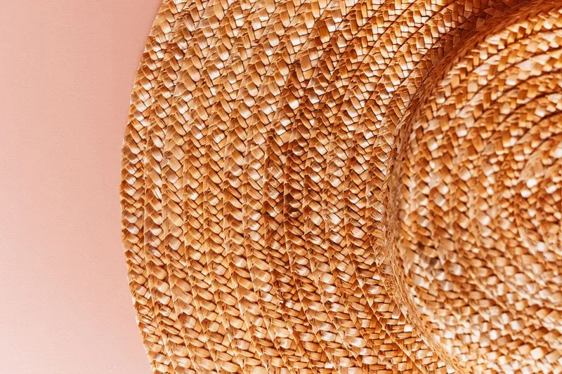Gros plan sur le tressage serré d'un chapeau de paille