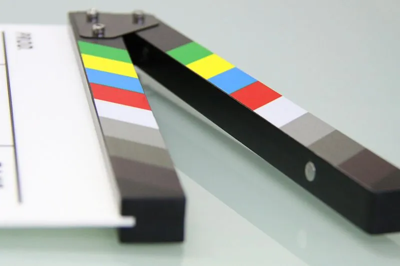 Clap de cinéma en gros plan, posé ouvert sur une surface réfléchissante