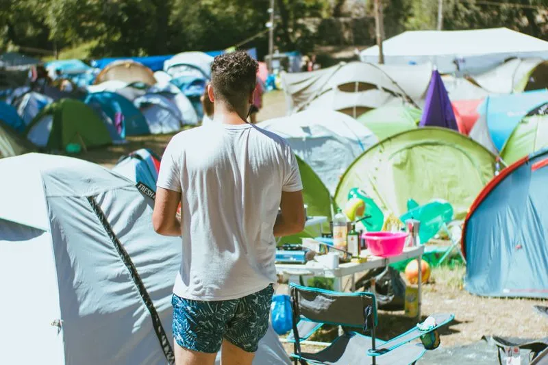 Tentes colorées serrées les unes contre les autres en plein jour dans un camping de festival