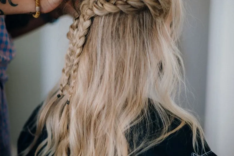 Vue de dos d'une tresse qui part du sommet du crâne et redescend le long de cheveux blonds