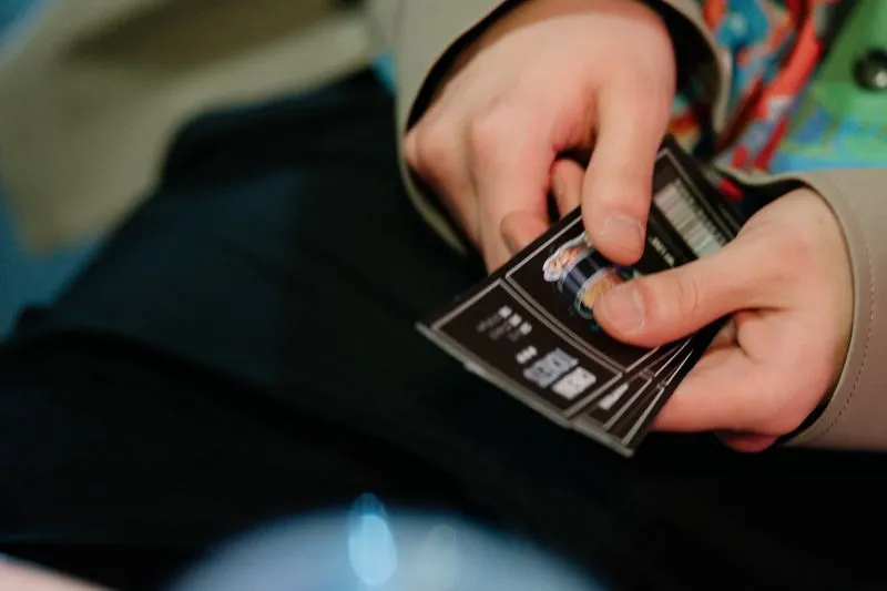 Gros plan sur des mains tenant plusieurs billets de cinéma en éventail