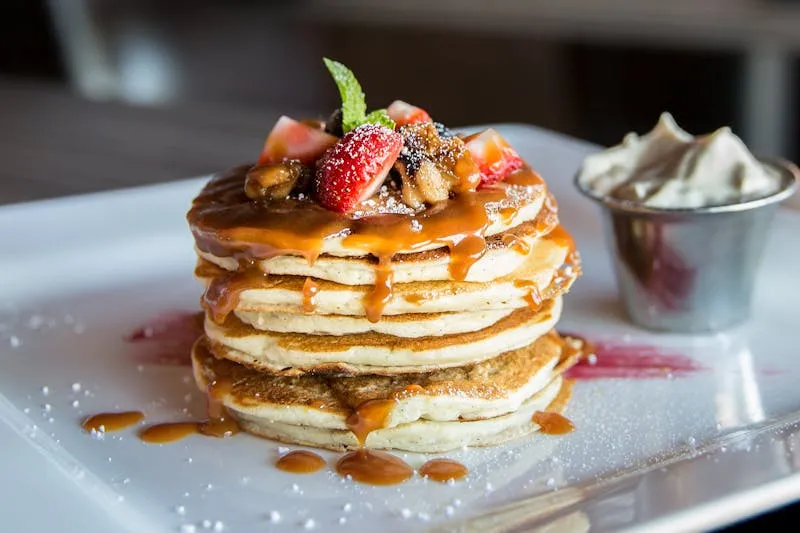 Pile de pancakes moelleux avec fruits rouges et sirop d'érable