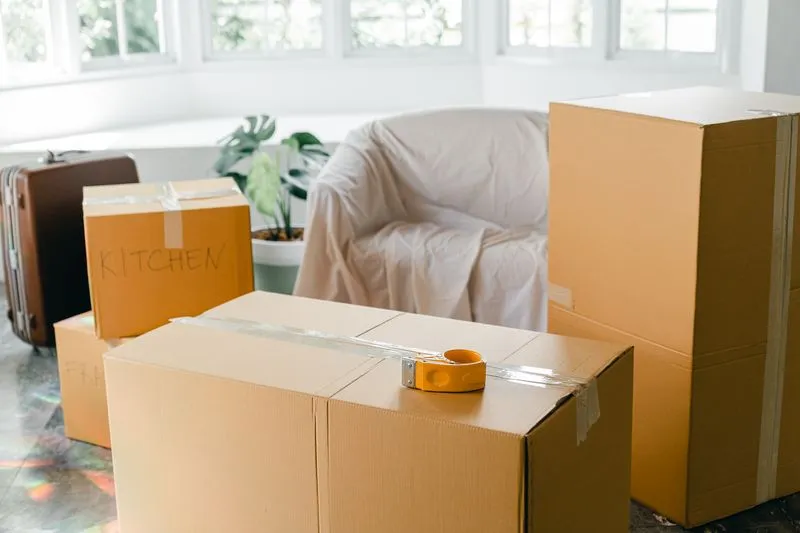 Cartons de déménagement empilés et étiquetés dans un appartement en cours de déménagement